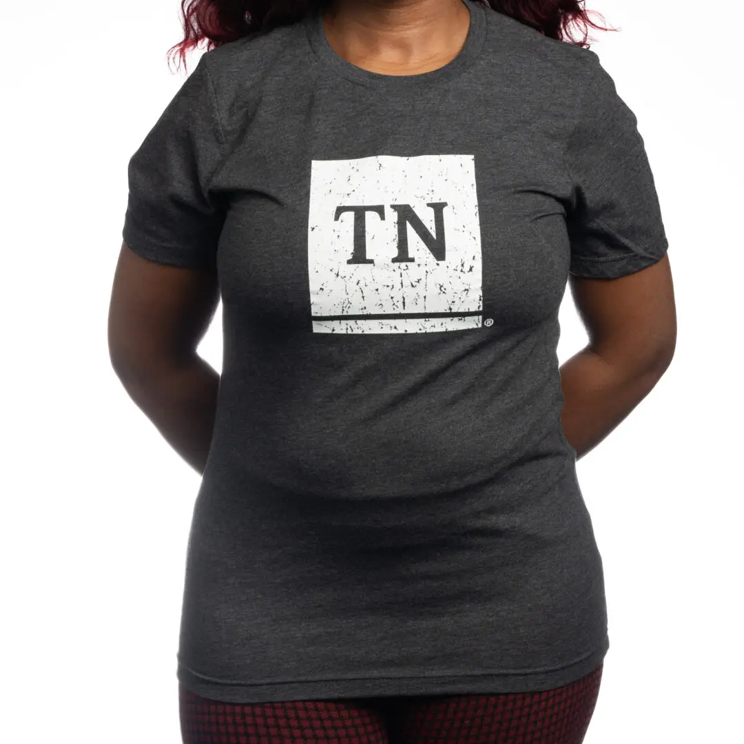 A woman wearing a t-shirt with the letter tn on it.