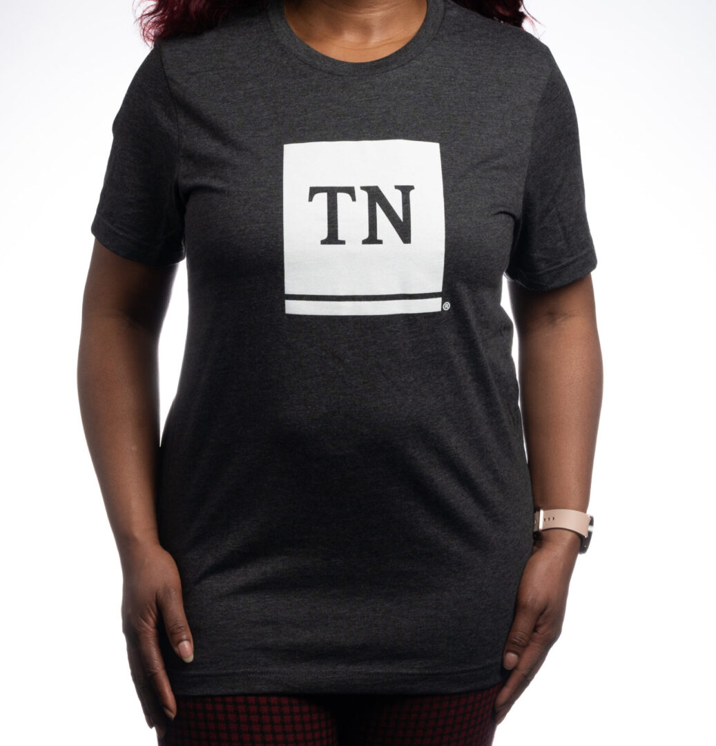 A woman wearing a black t-shirt with the letter tn on it.